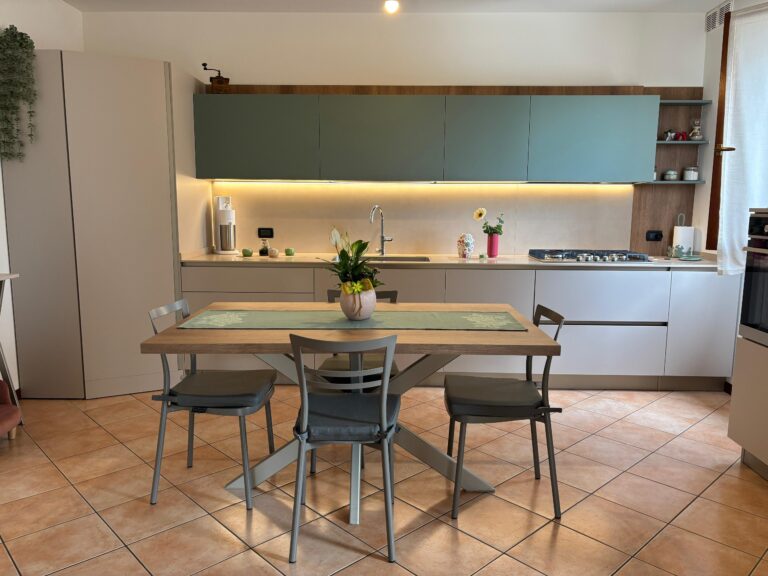 Cucina moderna su misura con pensili verde salvia e tavolo in legno realizzata da 2ZC Arredamenti